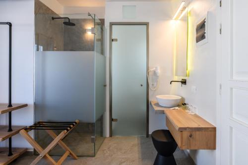 米克诺斯城马格斯酒店的一间带玻璃淋浴和水槽的浴室