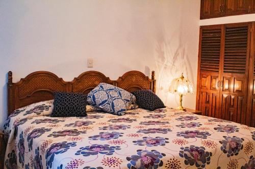 马斯科塔Villa Flores, casa en el centro de Mascota的一间卧室配有一张带花卉床罩的床