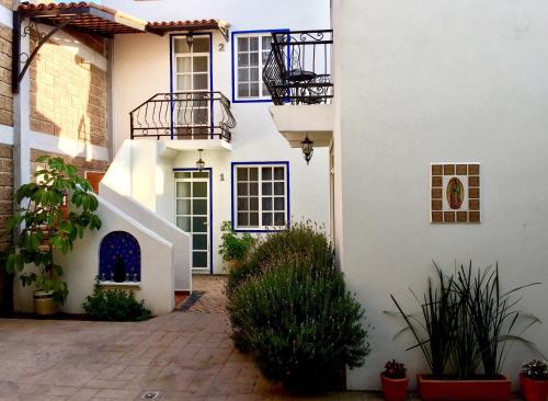 圣胡安特奥蒂瓦坎Villa Las Campanas的带阳台和植物的白色房屋