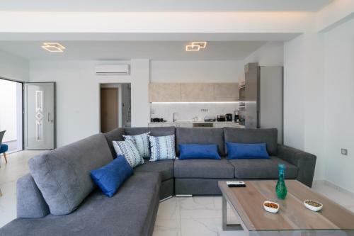 干尼亚Katakis LuxuryVillas的客厅配有灰色的沙发和蓝色的枕头。