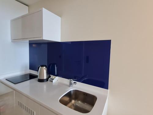 巴统Hotel Orbi City Sea Horizon的厨房设有水槽和蓝色的墙壁