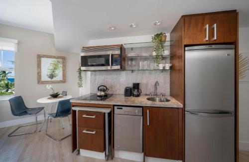 迈阿密海滩Strand Ocean Drive Suites的厨房配有不锈钢冰箱和水槽