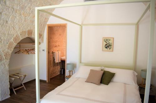 莫诺波利TRULIVO的卧室配有白色的玻璃天蓬床