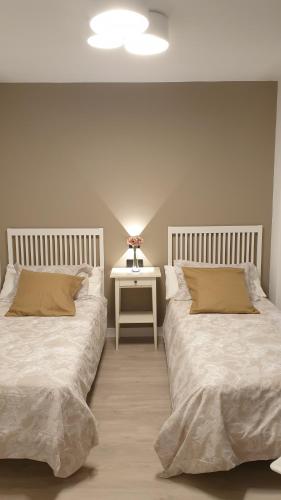 圣地亚哥－德孔波斯特拉Apartment Pontus Stellae的一间卧室配有两张床,还有一个床头柜和一张桌子