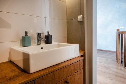 特伦钦ATRIO Apartments的木制柜台上带白色水槽的浴室