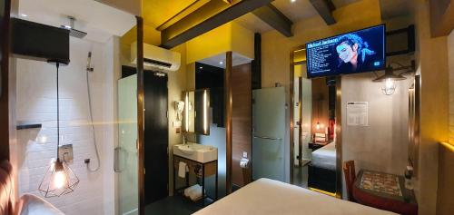 安吉利斯iOtel Luxury Kiosk Hotel的客房设有电视和带水槽的浴室