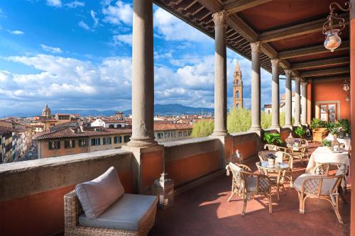 佛罗伦萨瓜达尼宫酒店的设有带桌椅的市景阳台。