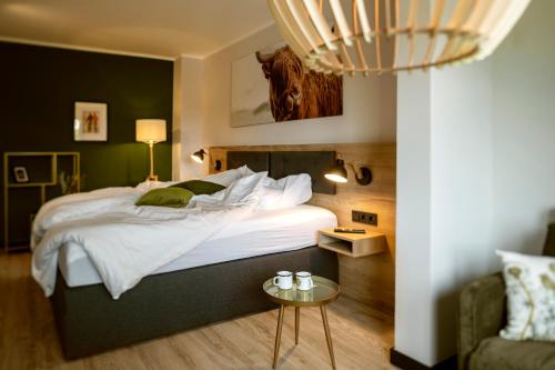 布劳恩拉格Berg und Tal Hotel & Apartments的一间卧室配有一张大床和一张桌子
