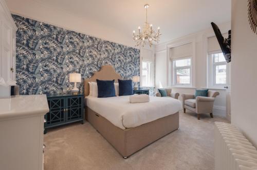 朴次茅斯Stattons Boutique Hotel & Restaurant的一间卧室配有一张蓝色和白色壁纸的床
