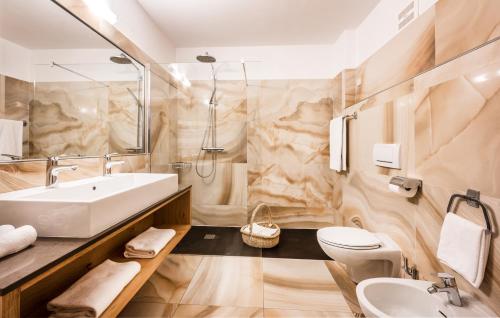 菲耶米拉蒙缇公园酒店的一间带水槽、卫生间和镜子的浴室