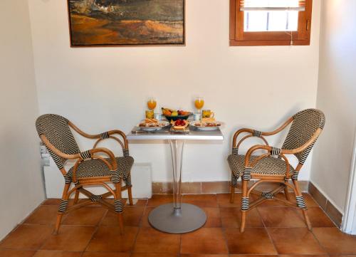 阿尔勒Loft Apartment , La Terrasse Centre Ville d'Arles,的两把椅子和一张桌子,上面有盘子的食物