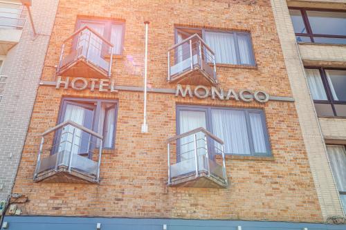 泽布吕赫Hotel Monaco Zeebrugge Beach的砖砌建筑,设有两扇窗户和酒店摩洛哥标志