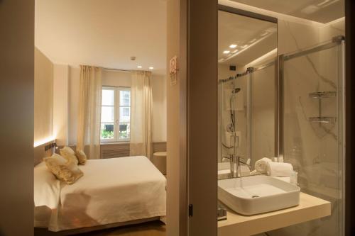 贝加莫Locanda Cavour的一间带床、水槽和淋浴的浴室