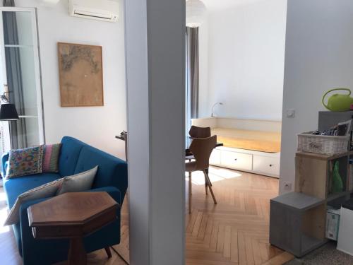 尼斯妮莎拉贝拉公寓的客厅配有蓝色的沙发和桌子