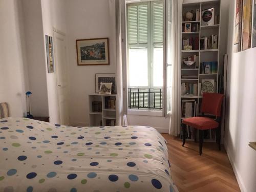 尼斯妮莎拉贝拉公寓的一间卧室设有一张床、一个窗口和一把椅子