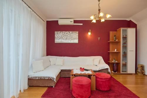 古维达里Agriculture & Holiday house Lasko的客厅配有白色沙发和红色墙壁