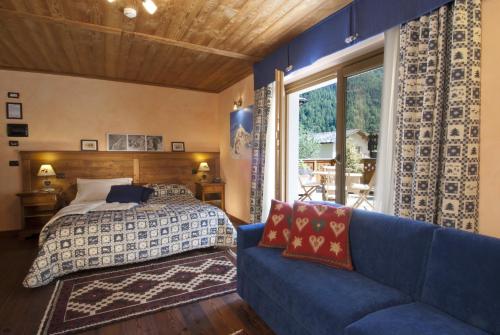 瓦托内切米拉蒙提旅馆的一间卧室配有一张床和一张蓝色的沙发