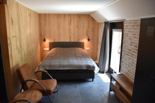 吕洛De Kasteelboerderij的卧室配有一张床铺,位于带木墙的房间内