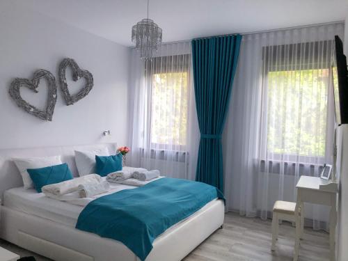 锡比乌Gizell Apartment 1的一间卧室配有一张带蓝色床单和蓝色窗帘的床。