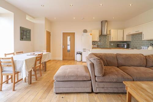 亚历山德里亚Fantastic Cottage in Loch Lomond National Park的客厅以及带沙发和桌子的厨房。