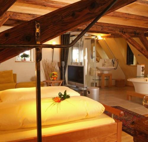 罗滕堡克劳斯叶思图布尔酒店的一间卧室配有一张床、一台电视和一间浴室。