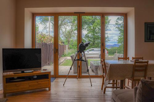 亚历山德里亚Fantastic Cottage in Loch Lomond National Park的客厅里三脚架上的摄像头,配有电视