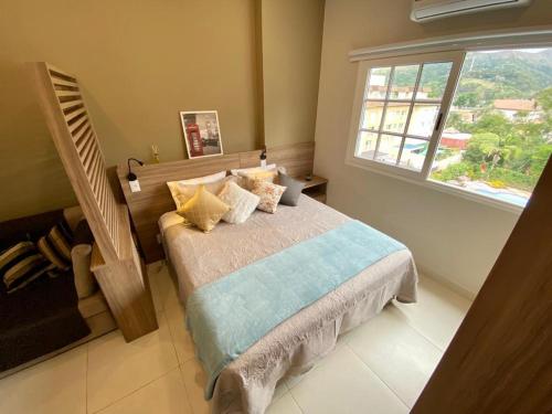 伊泰帕瓦Happy Flat Itaipava - Granja Brasil的一间卧室设有一张床和一个大窗户