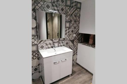 Clairvaux-dʼAveyronLe moulin des vignes的浴室设有白色水槽和镜子