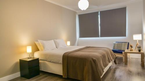 坎普自由鎮São Pedro Apartment的一间卧室设有一张床和一个大窗户