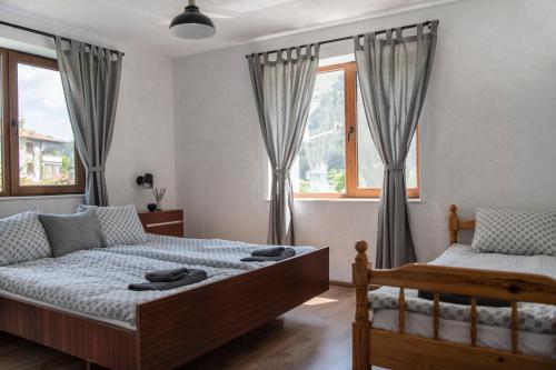 特里格拉德Къща До Гората Триград的一间卧室设有两张床和窗户。