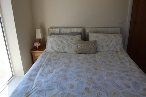 BallaghnatrillickBen Haven Self Catering Accommodation的一张带蓝色和黄色床罩和枕头的床