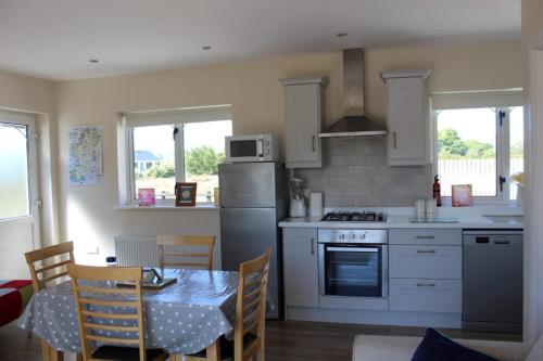 BallaghnatrillickBen Haven Self Catering Accommodation的一间带桌子的厨房和一间带桌椅的厨房