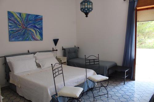莱乌卡Villa Pedaci B&B的一间卧室配有一张床、两把椅子和一幅画