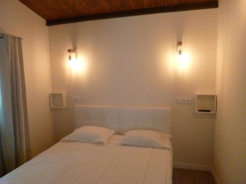 吉尔斯Casas das Guimbras的卧室配有白色的床和2个枕头