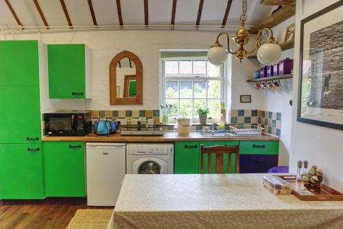 怀特帕里施Bramble Cottage的厨房配有绿色橱柜和水槽