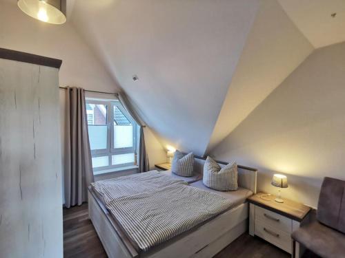 霍鲁梅尔希尔Ferienwohnung Langeneß的一间卧室设有一张大床和窗户
