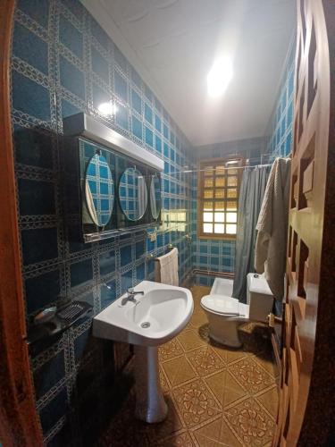 BarallaCaserío Félix的蓝色瓷砖浴室设有水槽和卫生间