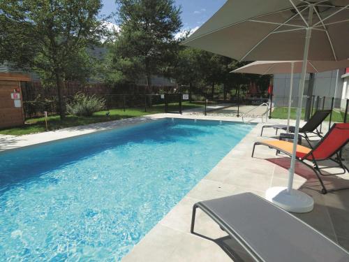 圣热尼普伊宜必思圣热尼普伊日内瓦酒店的一个带两把椅子和遮阳伞的游泳池
