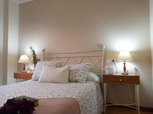 莫阿尼亚Itxi y Jamin - Chalet con vistas a la Ria de Vigo的一间卧室配有一张床、两个床头柜和两盏灯。