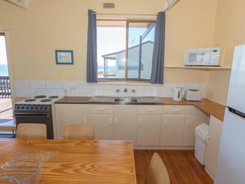 诺曼维尔Sandy Feet 31 Gold Coast Drive的厨房配有水槽和炉灶