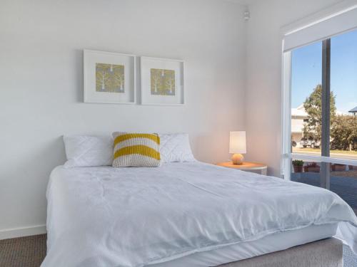 诺曼维尔Bungala Coastal Retreat 12 Nereus Drive的白色的卧室设有一张大床和一个窗户