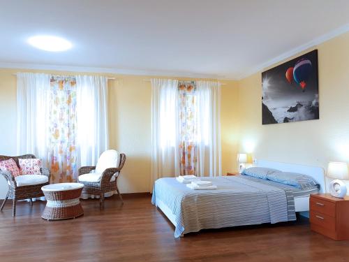 奥罗佩萨德尔马Villa con piscina的一间卧室配有一张床和两把椅子
