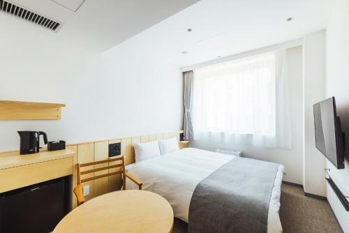 带广奴卡旅舍的一间酒店客房,配有一张床和一台电视