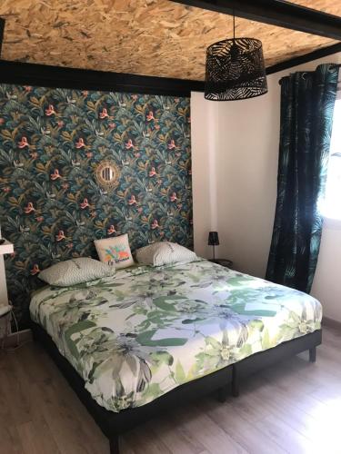 珀蒂蒂勒La Villa Citronnier的一间卧室配有一张带花卉壁纸的床