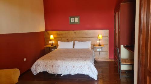 阿拉色那Hotel La Era de Aracena - Adults Only的一间卧室配有一张红色墙壁的床和两盏灯。