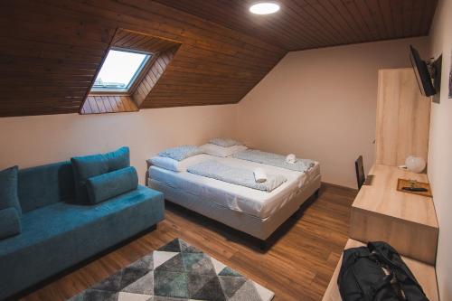 欧尔菲Natúra Panzió&Apartmanház的一间卧室配有一张床和一张沙发