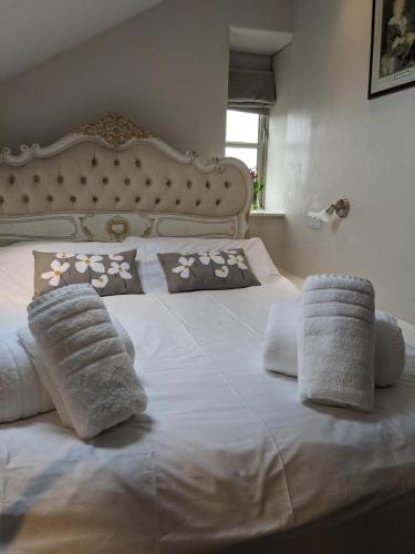 斯基普顿Pinfold Holiday Cottage的一张带枕头和毛巾的白色床