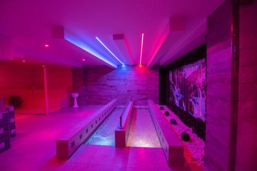 阿沃拉White Apartments & Spa的一间设有紫色灯光的游泳池的客房