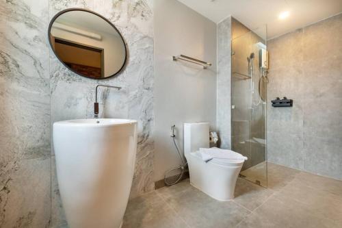 罗勇PLAAI Plus Hotel Rayong的一间带水槽、卫生间和镜子的浴室