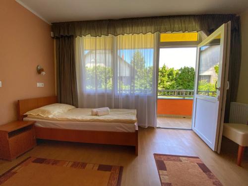 巴拉通马里亚弗都Arkánum Hotel的一间卧室设有一张床和一个阳台的窗户。
